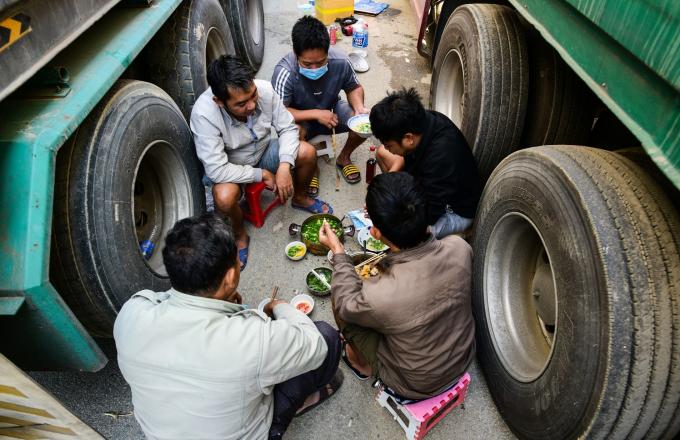 Kẹt trong bãi phi thuế quan nhiều ngày, các tài xế đã dần trở nên thân thiết. Thỉnh thoảng lại xin nhau quả ớt, quả chanh, hôm nào hết thức ăn mấy người tài xế lại góp vào nấu ăn chung cho tiết kiệm. Chưa biết khi nào sẽ được thông quan cũng không thể làm gì để giải quyết tình trạng hiện tại, họ chỉ còn cách chờ và phó mặc cho may rủi. Ảnh: Zingnews.vn