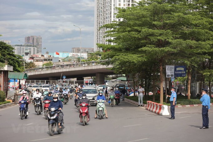 Đối với nút giao Ngã Tư Sở, cấm phương tiện đi thẳng, rẽ trái dưới gầm cầu Ngã Tư Sở theo hướng Nguyễn Trãi đi Tây Sơn, đường Láng. Phương tiện sẽ phải rẽ phải ở Trường Chinh sau đó quay đầu ở điểm mở cách Ngã Tư Sở 700 m và rẽ phải đi Tây Sơn hoặc đi thẳng để sang đường Láng. (Ảnh: Hoài Nam/Vietnam+)