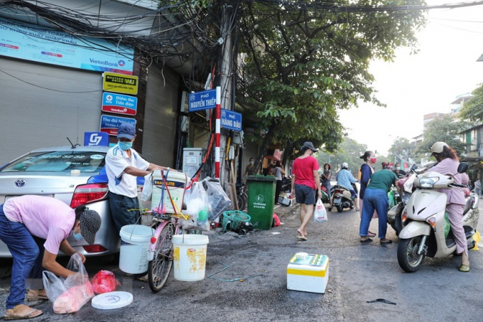 Các tiểu thương và người mua tiếp tục di chuyển xuống đoạn ngã ba Hàng Đậu - Nguyễn Thiệp để mua bán sau khi việc họp chợ khu vực bốt Hàng Đậu bị lực lượng chức năng giải tán. (Ảnh: Thành Đạt/TTXVN)