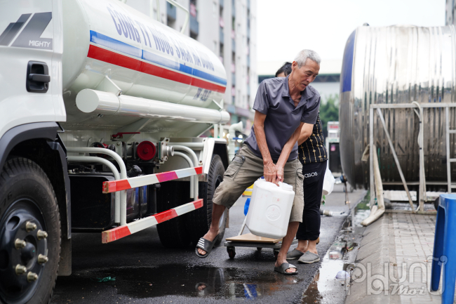 Ban ngày, người già thay nhau nhận nước từ xe téc của các mạnh thường quân và một số tổ chức, đơn vị khác điều đến. Họ không dám sử dụng nước máy do kết quả xét nghiệm mới đây cho thấy nước chứa E.coli, hàm lượng amoni và clo vượt hàng chục lần mức cho phép.