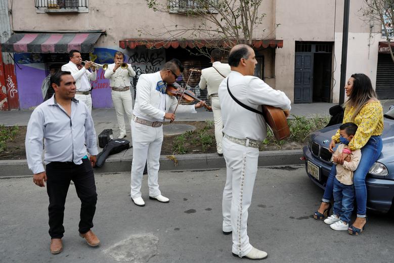  Một người mẹ thích thú với đứa con của mình bởi một ban nhạc Mariachi ở thành phố Mexico (ảnh trái) và một phụ nữ cùng người thân của những người mất tích tham gia tuần hành để yêu cầu sự giúp đỡ từ chính phủ Mexico.