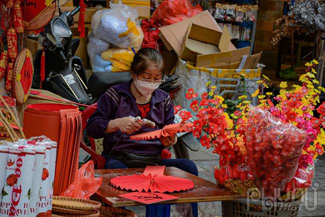 Cô Phương Nga, tiểu thương nhỏ trên phố Hàng Mã, chia sẻ: Năm nay vì dịch nên tôi tự làm đồ thủ công, cắt dán cho mới mẻ, sản phẩm kiểu này bán chạy vì còn có thể đặt làm theo yêu cầu của khách. Các sản phẩm đa dạng, đủ các loại kích cỡ lớn nhỏ, màu sắc chủ đạo luôn là màu đỏ và vàng như câu đối, đèn lồng, hoa giả hay đồ trang trí cây cối, nhà cửa. Vì theo truyền thống, hai màu này mang lại sự may mắn, thịnh vượng, no ấm... của bản thân, gia đình.  