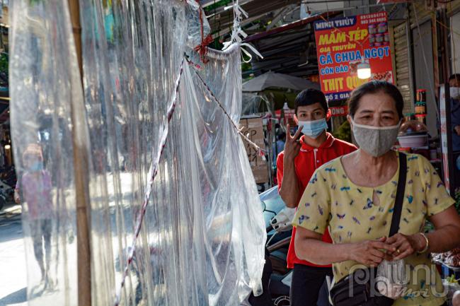 Các cửa hàng gần cửa tiếp xúc nhiều nên người dân căng tấm nilon chắn đảm bảo khoảng cách mua hàng.