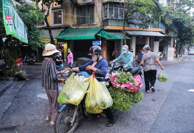 Các tiểu thương và người mua tiếp tục di chuyển xuống đoạn ngã ba Hàng Đậu-Nguyễn Thiệp để mua bán sau khi việc họp chợ khu vực bốt Hàng Đậu bị lực lượng chức năng giải tán. (Ảnh: Thành Đạt/TTXVN)