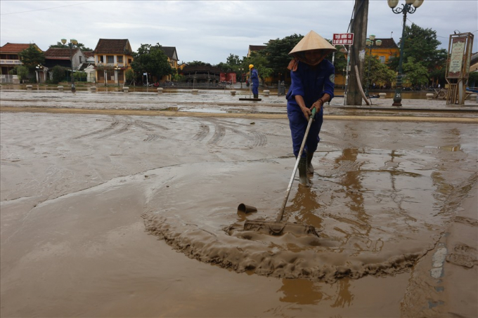 Công ty Cổ phần công trình công cộng Hội An huy động hơn 40 công nhân cùng 3 máy bơm lớn, 2 xe rửa đường để xử lý bùn lầy ngập ngụa sau lũ.