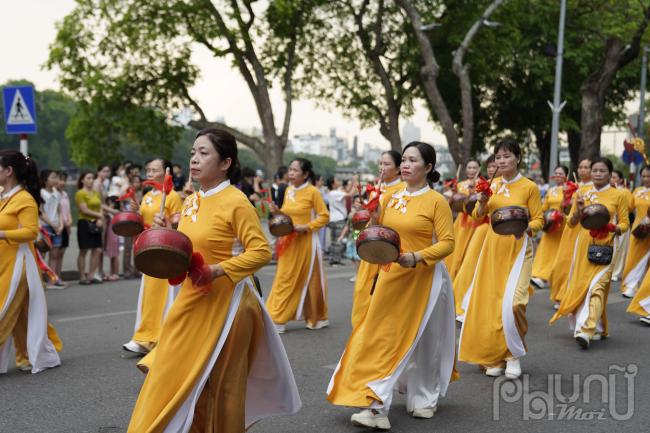 Những phụ nữ trung tuổi, thanh niên quận Hoàn Kiếm với trang phục màu vàng nổi bật đi đầu đoàn rước kiệu vua Lê Thái Tổ.