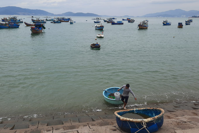 Ngư dân cũng bắt đầu di chuyển thúng, ghe, hải sản vào bờ.