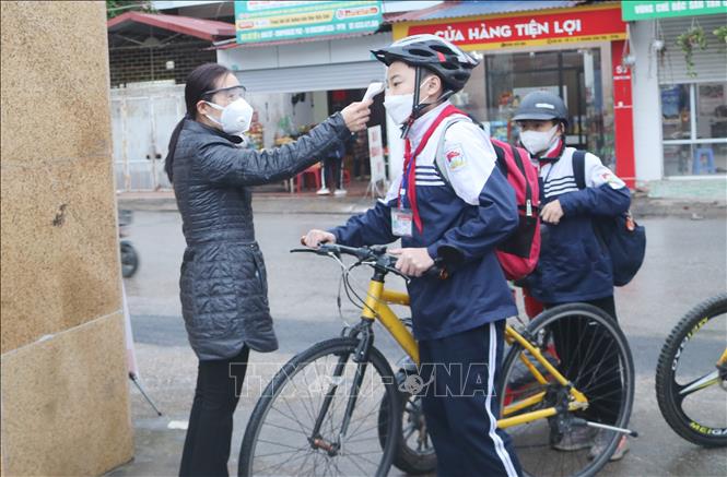 Đo thân nhiệt cho học sinh Trường THCS Nguyễn Du, thành phố Thái Nguyên trước khi vào lớp. Ảnh minh họa: TTXVN