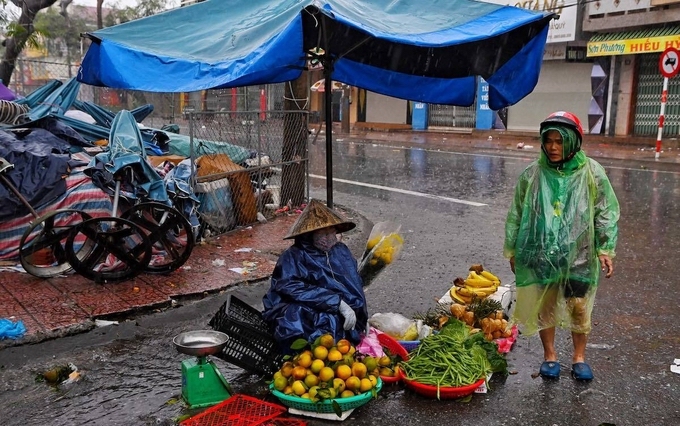 Bất chấp mưa gió, chợ cóc vẫn hoạt động giữa lúc bão đổ bộ. Ảnh: Việt Linh, Giang Huy 