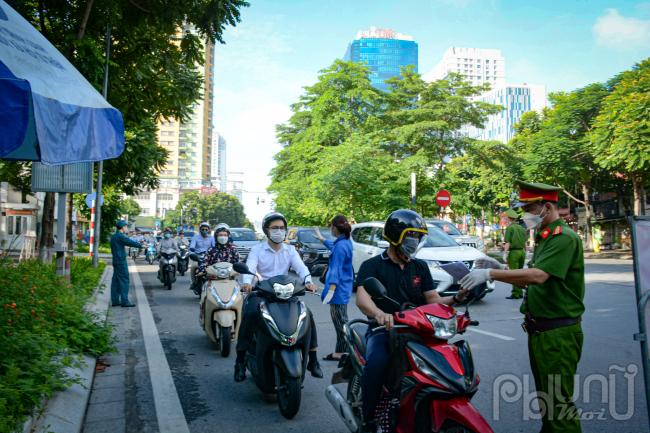 Phân luồng các phương tiện giao thông đồng thời nhắc nhở người dân chuẩn bị giấy đi đường khi qua chốt kiểm soát.