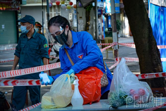 Lương thực được các lực lượng chức năng tiếp nhận phun khử khuẩn và đưa đến tận nhà cho các hộ dân.