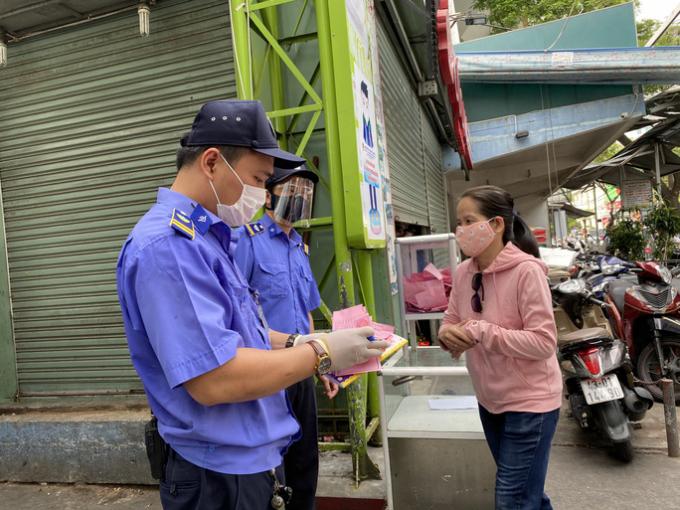 Trong ngày 12-8, người dân vào chợ phải mang theo phiếu màu hồng là quy định cho ngày chẵn. Người dân vào chợ Cồn - Đà Nẵng được kiểm tra qua chốt bảo vệ ở cổng chính.