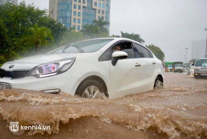   Nhiều ô tô chầm chậm di chuyển qua đoạn đường ngập sâu  